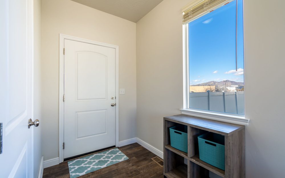 Small back entry with a door, a window and a cubby shelf with storage baskets