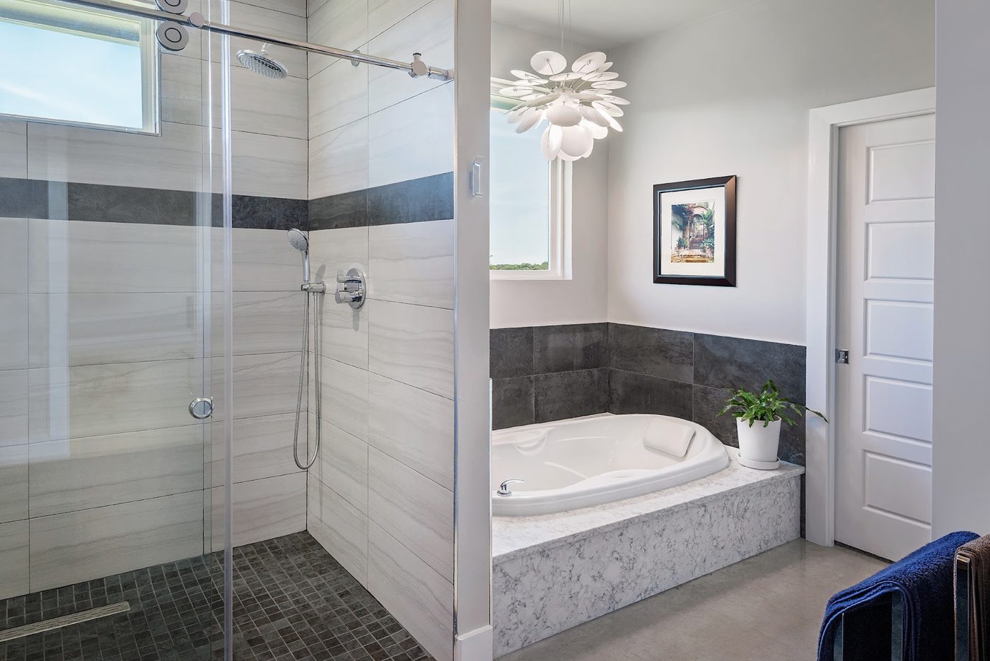 Finished bathroom with a frameless glass walk-in shower beside a tiled corner soaking tub, a KOI Build Co project