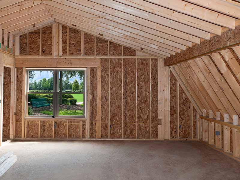 A room featuring wooden framing and large windows, allowing natural light to illuminate the space.